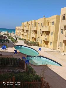 a swimming pool in front of some apartment buildings at Blue Lagoon Village Ras Sidr (قرية بلولاجون راس سدر) (عائلات فقط) in Ras Sedr