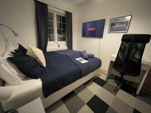 1 dormitorio con 1 cama, 1 silla y TV en 4-bedroom Villa with private gym and hot-tub en Reikiavik