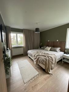 a bedroom with a large bed and two windows at 4-bedroom Villa with private gym and hot-tub in Reykjavík