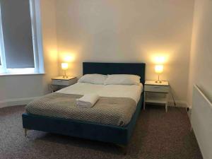 a bedroom with a bed and two lamps on two tables at Garden Flat in central location in London