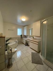 y baño con bañera, lavamanos y ducha. en 4-bedroom Villa with private gym and hot-tub, en Reikiavik