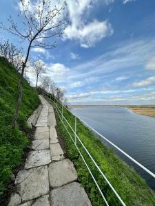 un sentiero di pietra accanto a un corpo d'acqua di Laguna Nuferilor Habitat a Somova