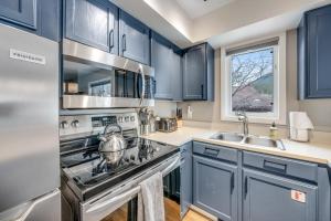 uma cozinha com armários azuis, um fogão e um lavatório em 2401 Pitchfork em Jackson