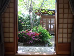- une fenêtre donnant sur un jardin fleuri dans l'établissement Sarangroo, à Jeonju