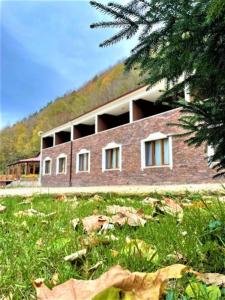 a brick building on a hill with a grass field at Feel & Live Hotel Villas Restaurant Sapanca in Sakarya