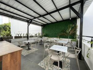 a restaurant with tables and chairs and a green wall at Hotel Amoek in Cartagena de Indias