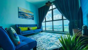 a blue living room with a blue couch and a large window at The Icon4 Condo in IOI City Mall Putrajaya, Netflix in Putrajaya
