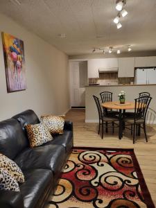 a living room with a leather couch and a table at Cozy Private Rooms in Suite in Edmonton