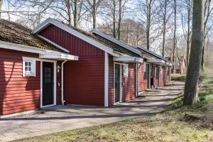 szereg czerwonych budynków z drzewami w tle w obiekcie Ringsjö Wärdshus Stugor w mieście Höör