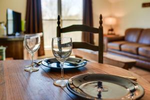 Una mesa con dos copas de vino y un plato encima. en Cozy Lewisburg Getaway with Deck and Lake Access!, en Lewisburg