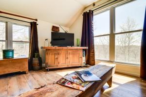 Una sala de estar con un televisor y una mesa. en Cozy Lewisburg Getaway with Deck and Lake Access!, en Lewisburg