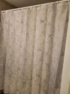 a white marble shower curtain in a bathroom at Cozy Private Rooms in Suite in Edmonton
