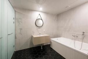 a bathroom with a tub and a sink and a mirror at Browndot hotel Guseo in Busan