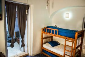 a bedroom with two bunk beds and a window at Gente de Más Hostel in Puebla