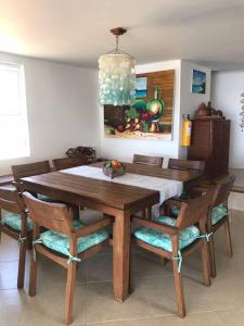 a wooden dining room table with chairs and aendant light at Marie Joseph Villa in San Andrés