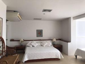 a bedroom with a bed with two tables and two lamps at Marie Joseph Villa in San Andrés