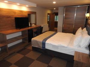 a hotel room with a bed and a desk and a television at Feel & Live Hotel Villas Restaurant Sapanca in Sakarya
