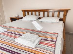 1 cama con 2 almohadas blancas en una manta a rayas en BOLU da ormanin tam kalbinde İsveç mimari göl manz, en Kemaller