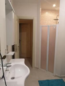 La salle de bains est pourvue d'un lavabo blanc et d'une douche. dans l'établissement BOLU da ormanin tam kalbinde İsveç mimari göl manz, à Kemaller