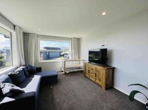 a living room with a couch and a flat screen tv at Lovely Family Home in Aotea with Grear Views - No Parties or Smoking in Porirua