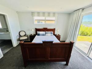 a bedroom with a bed and a large window at Lovely Family Home in Aotea with Grear Views - No Parties or Smoking in Porirua