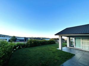 a backyard of a house with a lawn at Lovely Family Home in Aotea with Grear Views - No Parties or Smoking in Porirua