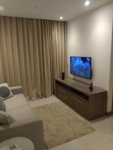 a living room with a flat screen tv on a cabinet at Flat Grand Midas- Rio Centro- Rock in Rio- Farmasi Arena- Projac- Barra- Parque Olimpico in Rio de Janeiro