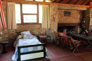 Zimmer mit einem Bett und einem gemauerten Kamin in der Unterkunft LUNA CAUTIVA in Santa Rosa de Calamuchita