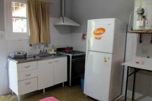 eine Küche mit einem weißen Kühlschrank und einem Herd in der Unterkunft LUNA CAUTIVA in Santa Rosa de Calamuchita + 52 Fotos