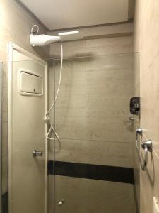 ジョアンペソアにあるMAR DO CABO BRANCO YELLOW residenceのバスルーム(ガラスドア付きのシャワー付)