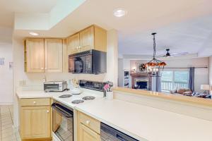 a kitchen with wooden cabinets and a white counter top at Chateau Sunrise - Solitude Village K203 in Ludlow