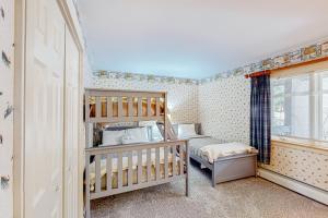 a small bedroom with a crib and a bunk bed at Chateau Sunrise - Solitude Village K203 in Ludlow +30 photos