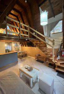 una gran sala de estar con una escalera y una mesa en del ANDINO.USH en Ushuaia