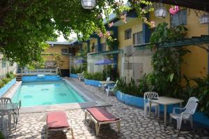 a swimming pool with chairs and a table next to a building at 2 Hotel Saleh in Angeles