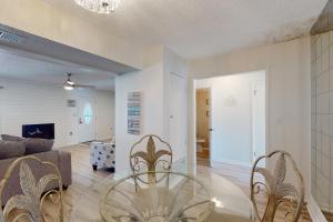 un salon avec une table en verre et des chaises dans l'établissement Sugar Reef Cottage #4, à Fort Walton Beach