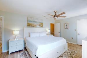Schlafzimmer mit einem weißen Bett und einem Deckenventilator in der Unterkunft Sugar Reef Cottage #4 in Fort Walton Beach
