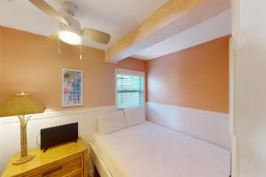 a small bedroom with a bed and a window at Sea Cabin 2D in Destin +16 photos