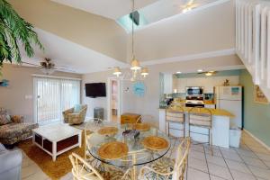 a kitchen and living room with a glass table and chairs at Sea Cabin 2D in Destin