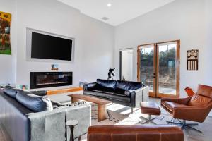 a living room with leather furniture and a flat screen tv at Casa Nicole in Yucca Valley