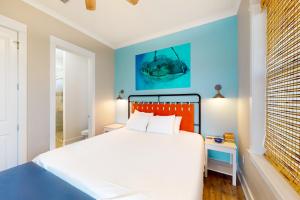 een slaapkamer met een bed en een blauwe muur bij East Side Cottages #C- Shipwreck Cottage in Gulf Shores