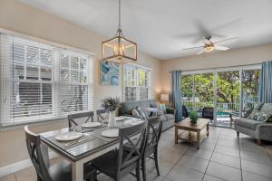 a dining room and living room with a table and chairs at Palm Villa in Duck Key