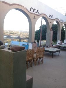 a patio with chairs and tables and arches at Omay ka in Aswan