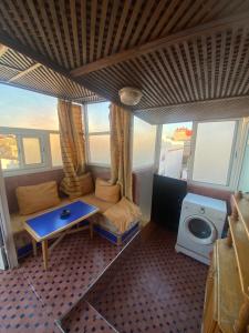 Maison traditionnelle de lahbib في الرباط: غرفة صغيرة مع أريكة وطاولة وتلفزيون