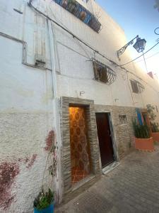 um edifício branco com uma porta e uma janela em Maison traditionnelle de lahbib em Rabat