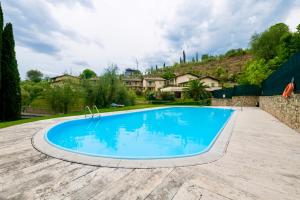 une grande piscine bleue dans une cour dans l'établissement Vittoriale - Pool and Parking, à Gardone Riviera