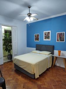 een blauwe slaapkamer met een bed en een plafondventilator bij Apto Carmen e Luis in Rio de Janeiro
