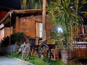 uma bicicleta estacionada em frente a uma casa em Hostel Trópico de Capricórnio - Vermelha do Centro em Ubatuba