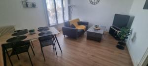 - un salon avec un canapé et une table avec des chaises dans l'établissement Chez Toni, à Troyes