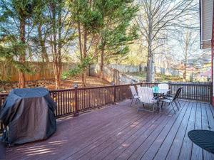 un patio con mesa y sillas en una terraza de madera en Atlanta's Metropolitan Heart, en Atlanta