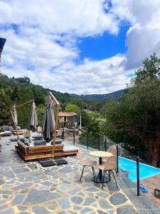 a patio with a table and chairs and a pool at Moinhos do Paiva in Castelo de Paiva